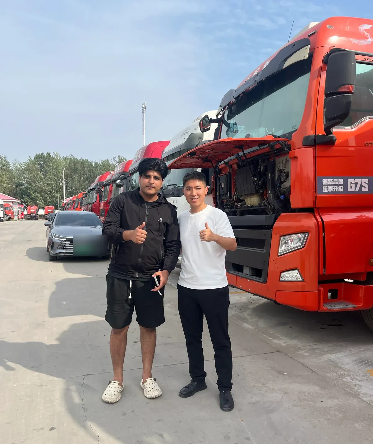 Team QIXIN SUPPLY con un acquirente internazionale nel piazzale veicoli